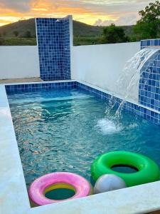 a swimming pool with a water fountain at Vila Negreiros Serra Negra Casa 4 in Bezerros
