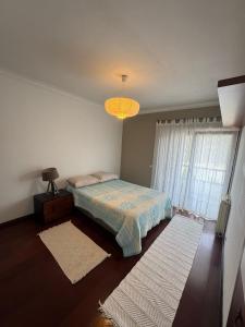 a bedroom with a bed and a large window at A Casa de São Pedro de Moel in São Pedro de Moel +42 photos