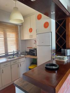 a kitchen with white cabinets and a wooden counter top at A Casa de São Pedro de Moel in São Pedro de Moel