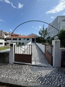 an open gate with a stone walkway in front of a building at A Casa de São Pedro de Moel in São Pedro de Moel