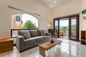 a living room with a couch and a table at Top-Floor Condo with Sweeping Ocean, Mountain & Marina Views in Playa Flamingo