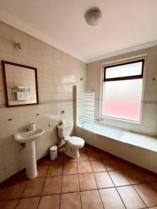 a bathroom with a toilet and a tub and a sink at CHALET CHAPITAL Punta Arenas in Punta Arenas