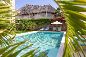 a swimming pool in front of a villa at Serenity Penthouse Watamu in Watamu
