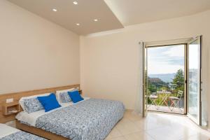 a bedroom with two beds and a large window at Vittoria Luxury Suite in Vico Equense
