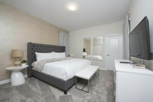 een slaapkamer met een bed en een flatscreen-tv bij Modern Home with Private Pool and Game Room at Storey Lake SL2742 in Kissimmee +67 foto's