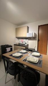 a kitchen with a table with plates on it at Apto inteiro no centro de caruaru para 2 pessoas in Caruaru
