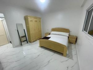 a bedroom with a bed and a wooden cabinet at Passo 1ér étage centre ville in Nador