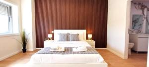 a bedroom with a large white bed with two lamps at Suite Room With Balcony and Douro Views in Valbom +7 photos