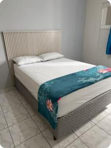 a bed with a blanket on top of it at Edifício Gorja in Praia Grande +12 photos