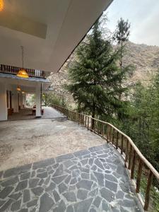 a house with a walkway with a tree on it at The Woods - Tirthan Valley in Gushaini +33 photos