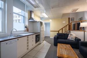 a kitchen and a living room with a couch at Handy Inner City Apartment in Dunedin