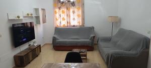 a living room with two chairs and a flat screen tv at Apartamento Completo Supreme Suite in Carboneras
