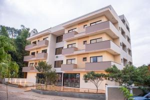 an apartment building with balconies and trees at Hotel Quinta do Lago in Cunha