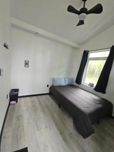 een slaapkamer met een bed, een raam en een plafondventilator bij Adventure Trail Cabin #9 in Houston