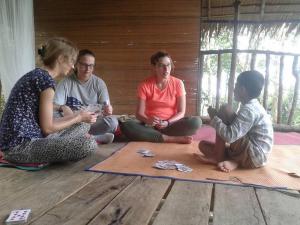 un gruppo di persone seduti sul pavimento insieme di WOOD CABIN LODGE IN THE FOREST book here treking with us a Bukit Lawang