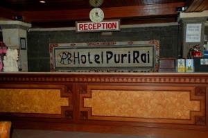 a hotel purrat sign on the counter of a restaurant at Puri Rai Hotel in Padangbai