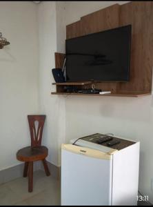 een tv op de top van een witte koelkast bij Pousada Café Villa Monnaié in Chapada dos Guimarães