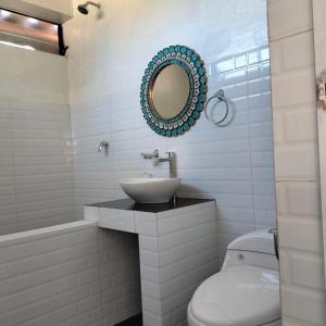 a bathroom with a sink and a toilet and a mirror at Tikary Lodge in Cusco