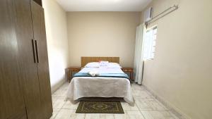 a bedroom with a bed in a room with a window at Casa Aconchegante Sete Lagoas - 35A in Sete Lagoas