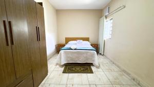 a bedroom with a bed in the corner of a room at Casa Aconchegante Sete Lagoas - 35A in Sete Lagoas