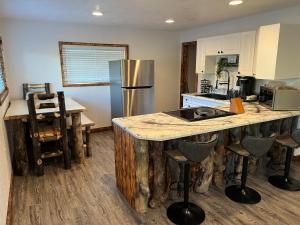 a kitchen with a refrigerator and a counter with bar stools at Home Between Zion & Bryce Canyon in Glendale