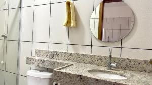 a bathroom with a sink and a mirror and a toilet at Casa 3Km do centro Sete Lagoas - 35 in Sete Lagoas +17 photos
