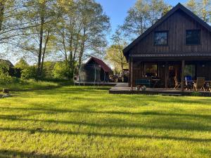 a house with a large yard with a grass field at Dom na Perłowej in Kopalino