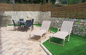 patio con tavolo e sedie in erba di Dolphin Apartments a Paleokastritsa Altre 31 foto