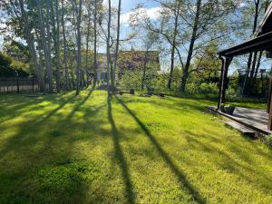 a long shadow of a building on a lawn at Dom na Perłowej in Kopalino