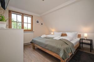 a bedroom with a bed with white sheets and a window at Ferienwohnung-Am-Hoepen in Rechlin