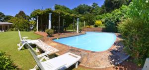 a swimming pool in a yard with a bench next to it at Brevisbrook B&B in Pietermaritzburg