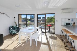 ein weißes Esszimmer mit einem weißen Tisch und Stühlen in der Unterkunft Canal 7 - On The Mooloolaba Canal in Mooloolaba + 8 Fotos