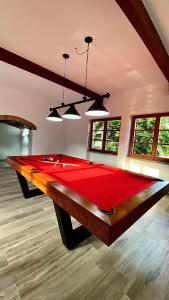 a large red pool table in a room with windows at Villa Casavecchia Caselli in Dicomano +32 photos