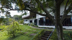 a building with a tree in front of it at Centro de Lazer Pingo d'água in Caxambu
