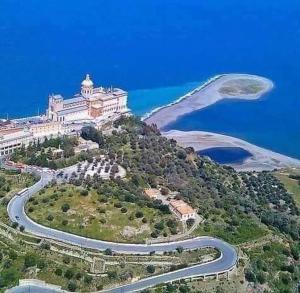 a large building on top of a hill with a winding road at Le Stelle Del Tirreno in Falcone +10 photos
