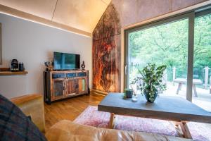 a living room with a table and a large window at Rosemary Lodge 2BR with Hot Tub and Sauna near Black Mountain in Garnant