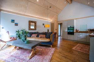 a living room with a couch and a table at Rosemary Lodge 2BR with Hot Tub and Sauna near Black Mountain in Garnant