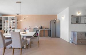 a kitchen and dining room with a table and a refrigerator at 2 Bedroom Nice Apartment In Brodarica in Brodarica