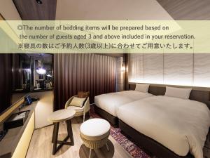 a hotel room with a bed and a table and stool at Beppu SUGINOI HOTEL in Beppu