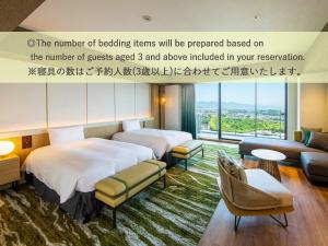 a hotel room with two beds and a couch at Beppu SUGINOI HOTEL in Beppu