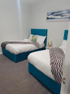 two beds sitting next to each other in a room at Rochester Castle, 2 Bed Modern Apartment in Wainscot