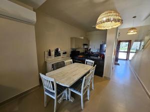 a kitchen with a wooden table and chairs and a chandelier at Private villa - Azha Ein Sokhna - Families only in Ain Sokhna