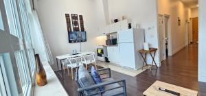 a living room with a white refrigerator and a table at Perfect Location! Quiet-Spacious-2 Bed-2 Bath in Windsor