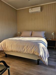 a bedroom with a bed and a chair in it at La Recompensa Tiny in Colonia Nuevo Paysandú