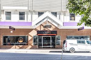 ブリスベンにあるTequila Sunrise Podstel Brisbaneの建物の前に駐車された白いバン