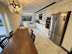 a kitchen with a wooden table and a stainless steel refrigerator at Nar Villa in Alanya
