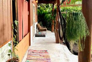 a porch with a hammock on the side of a house at Studio Phoenix Pet Friendly Near Black Sand Beach & Volcanic Forest in Pahoa +21 photos