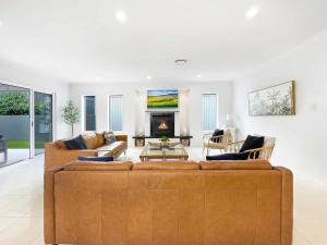 a living room with a couch and a fireplace at Relaxed Luxury for Families by the Beach in Buddina +23 photos