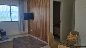 a living room with a glass table and chairs at Apartamento a Beira mar de Maceió in Maceió