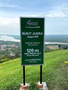 a sign on top of a hill with the ocean in the background at Tanah Embah RumahLima melayu sahaja in Banting +3 photos